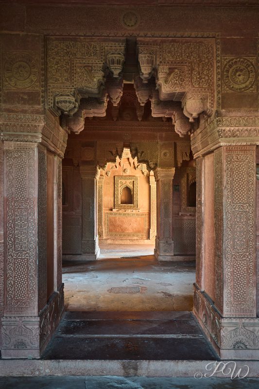 A sequence of carved stone arches framing a long passageway
