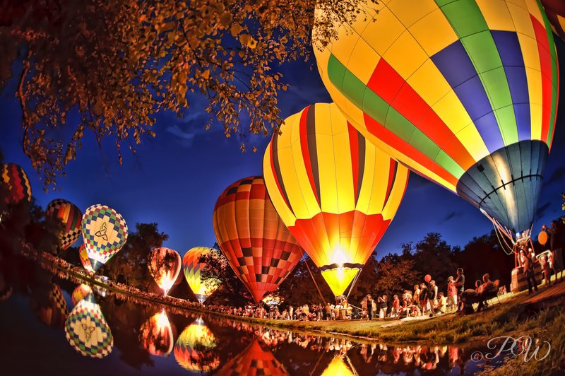 A row of glowing hot air balloons at dusk