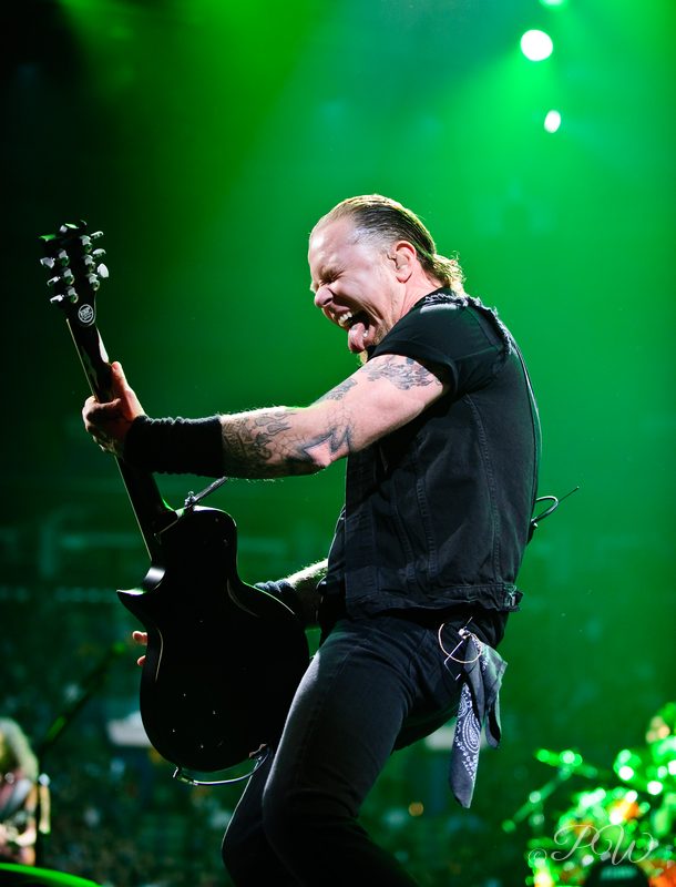 A Metallica guitarist playing under green stage light