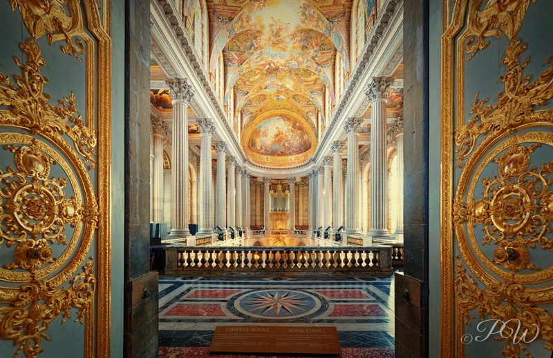 A gilded doorway frames a view down an ornate chapel to the altar