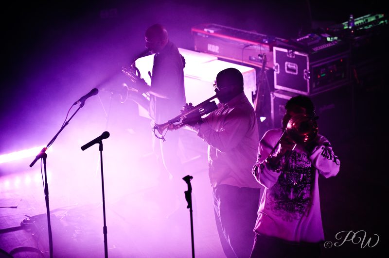 Galactic performing on a stage bathed in purple light