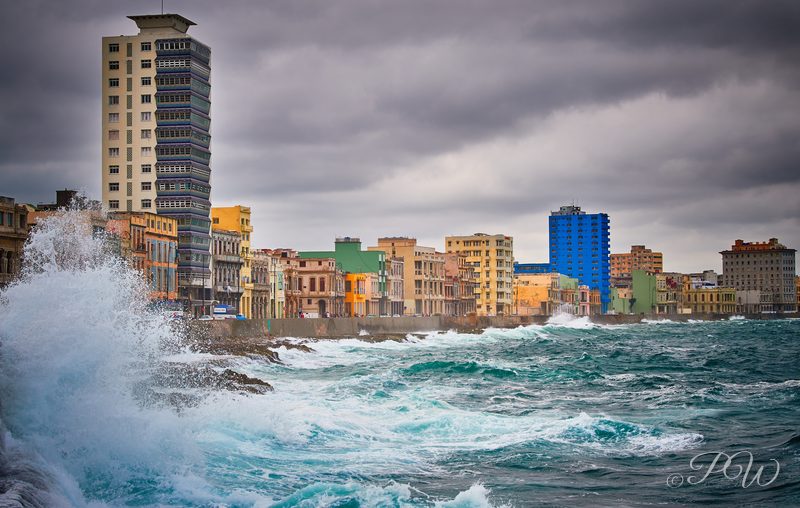Waves crash against the Malecón sea wall below Havana's waterfront buildings