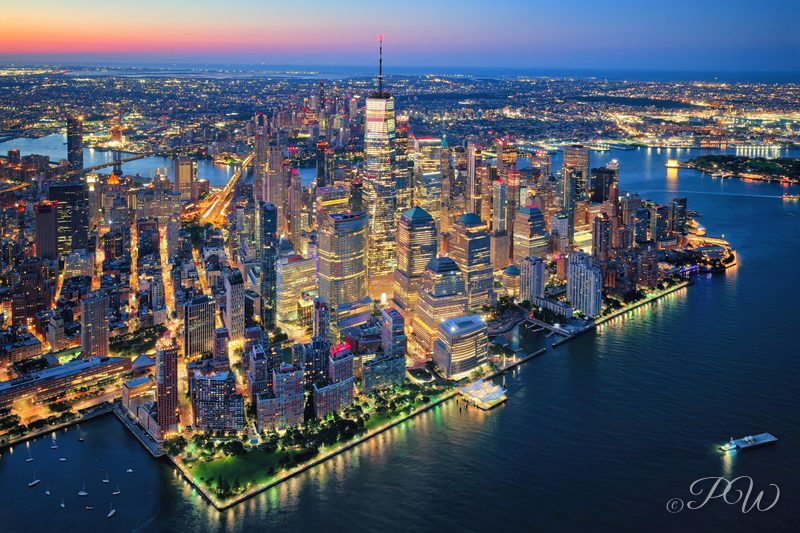 Aerial view of Lower Manhattan and One World Trade Center lit at dusk