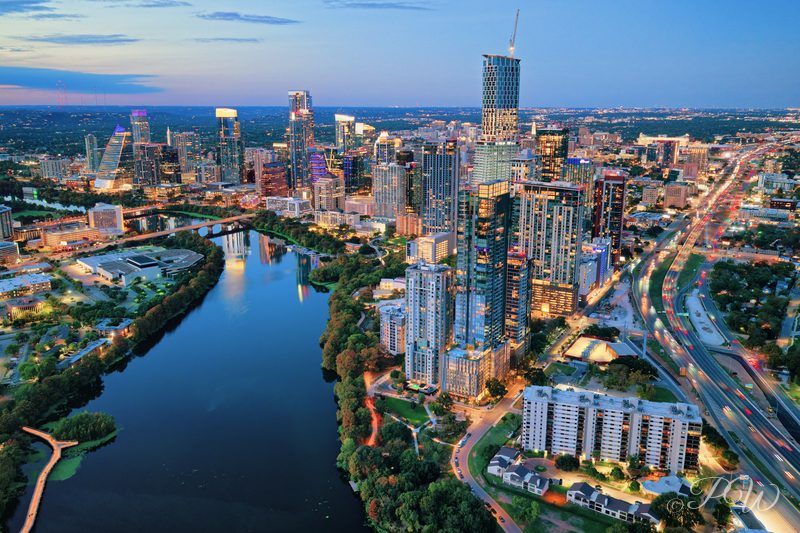 Aerial view of the Austin skyline beside the river at dusk