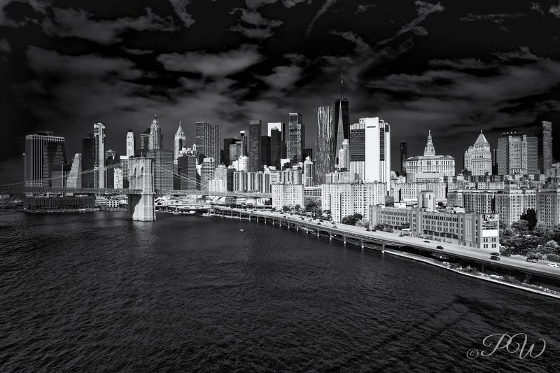 The Brooklyn Bridge and the Manhattan skyline across the East River in black and white